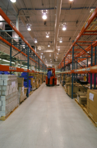 Forklift in large warehouse aisle.