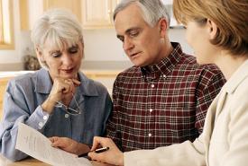 Here's an alt tag for the image: Financial advisor meeting with senior couple.