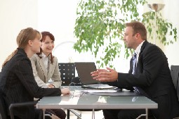 Here's an alt tag for the image: Businessman meeting with two colleagues.