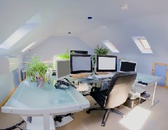 Here's an alt tag for the image: `Converted attic home office with multiple monitors`