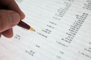 Hand reviewing financial data on paper.