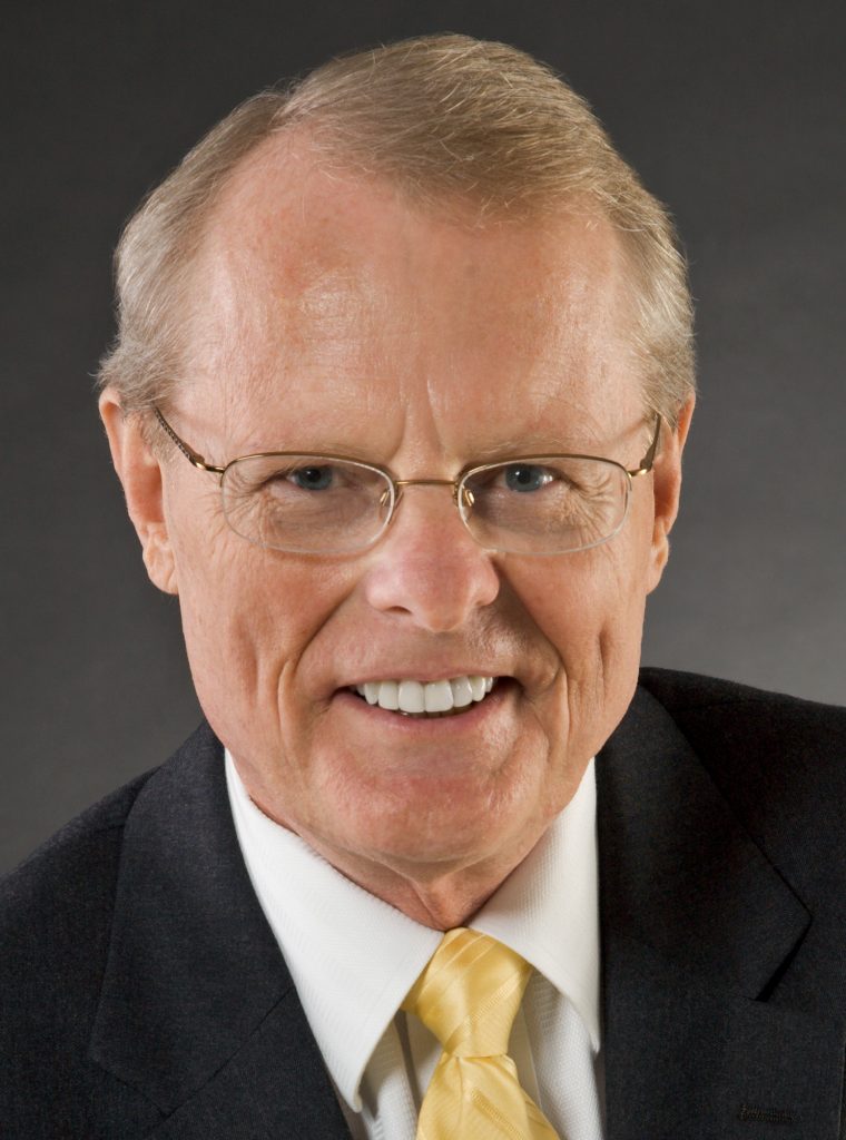 Smiling businessman in suit and glasses.