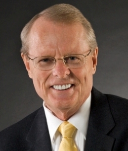 A man in suit and tie smiling for the camera.