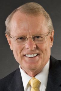 A man with glasses and a suit on.