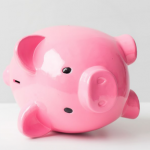 Here's an alt tag for the image: Pink piggy bank lying on its back.