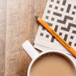 Here's an alt tag for the image: `Coffee, crossword puzzle, and pen`